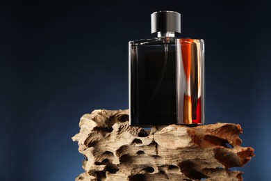 Luxury men`s perfume in bottle against dark background, space for text