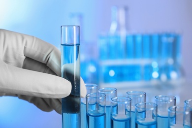 Scientist holding test tube with sample, closeup. Laboratory analysis