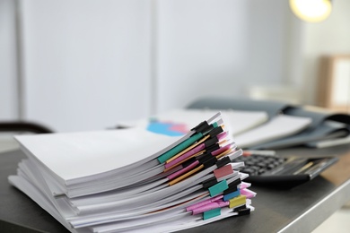 Photo of Stack of documents with paper clips on office table. Space for text