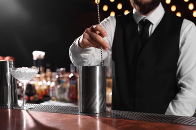 Photo of Bartender preparing fresh alcoholic cocktail at bar counter, closeup