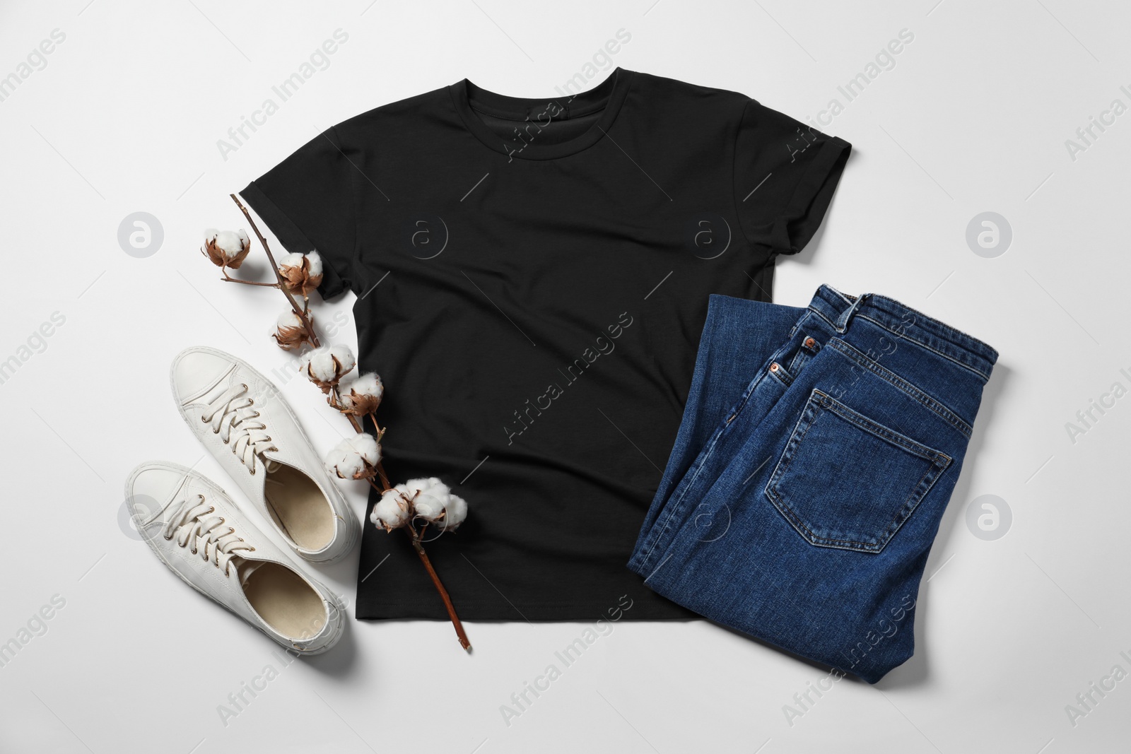 Photo of Stylish t-shirt, jeans and sneakers on white background, flat lay