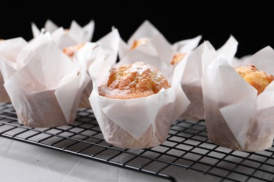Photo of Delicious muffins with powdered sugar on light table, closeup