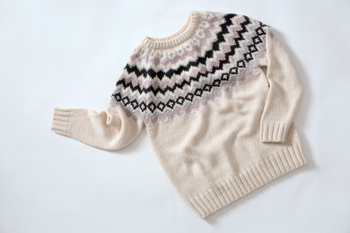 Top view of cozy knitted sweater on white background