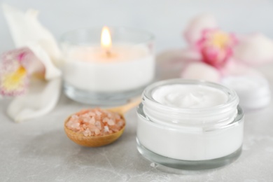 Beautiful spa composition with cream and sea salt on marble table, closeup