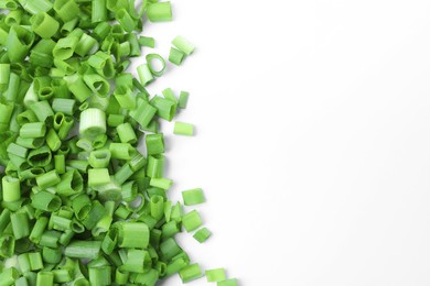 Photo of Chopped fresh green onion on white background, flat lay, space for text