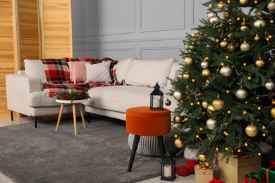 Beautiful Christmas tree, gift boxes and sofa in living room