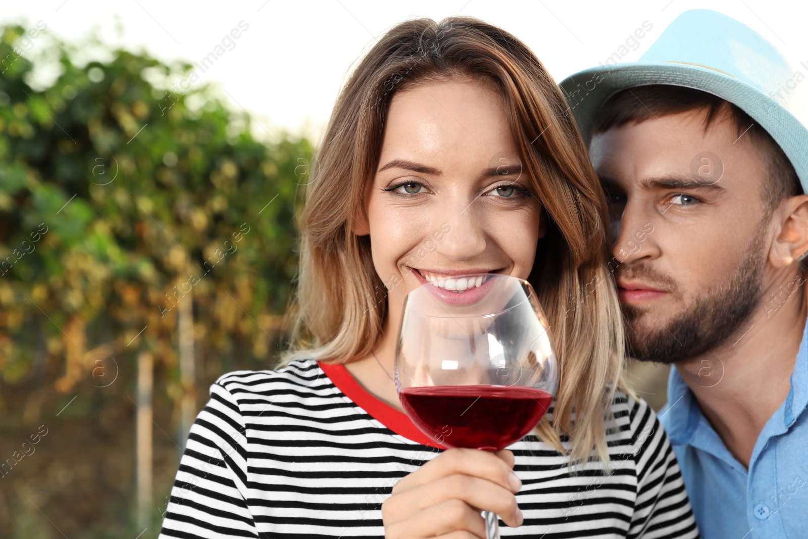 Photo of Young couple with glass of wine at vineyard