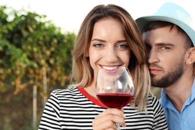 Young couple with glass of wine at vineyard