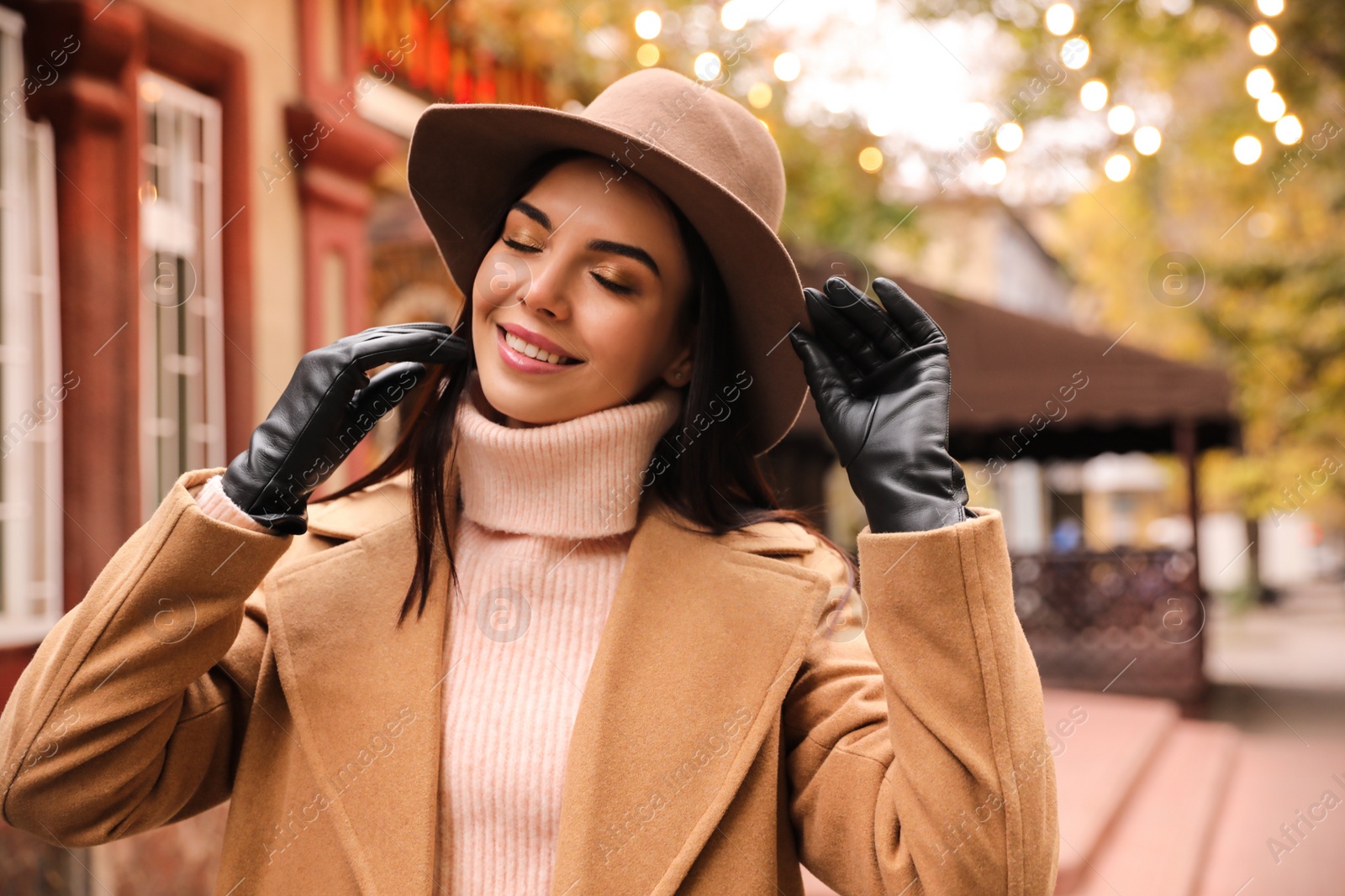 Photo of Young woman wearing stylish clothes on city street. Autumn look