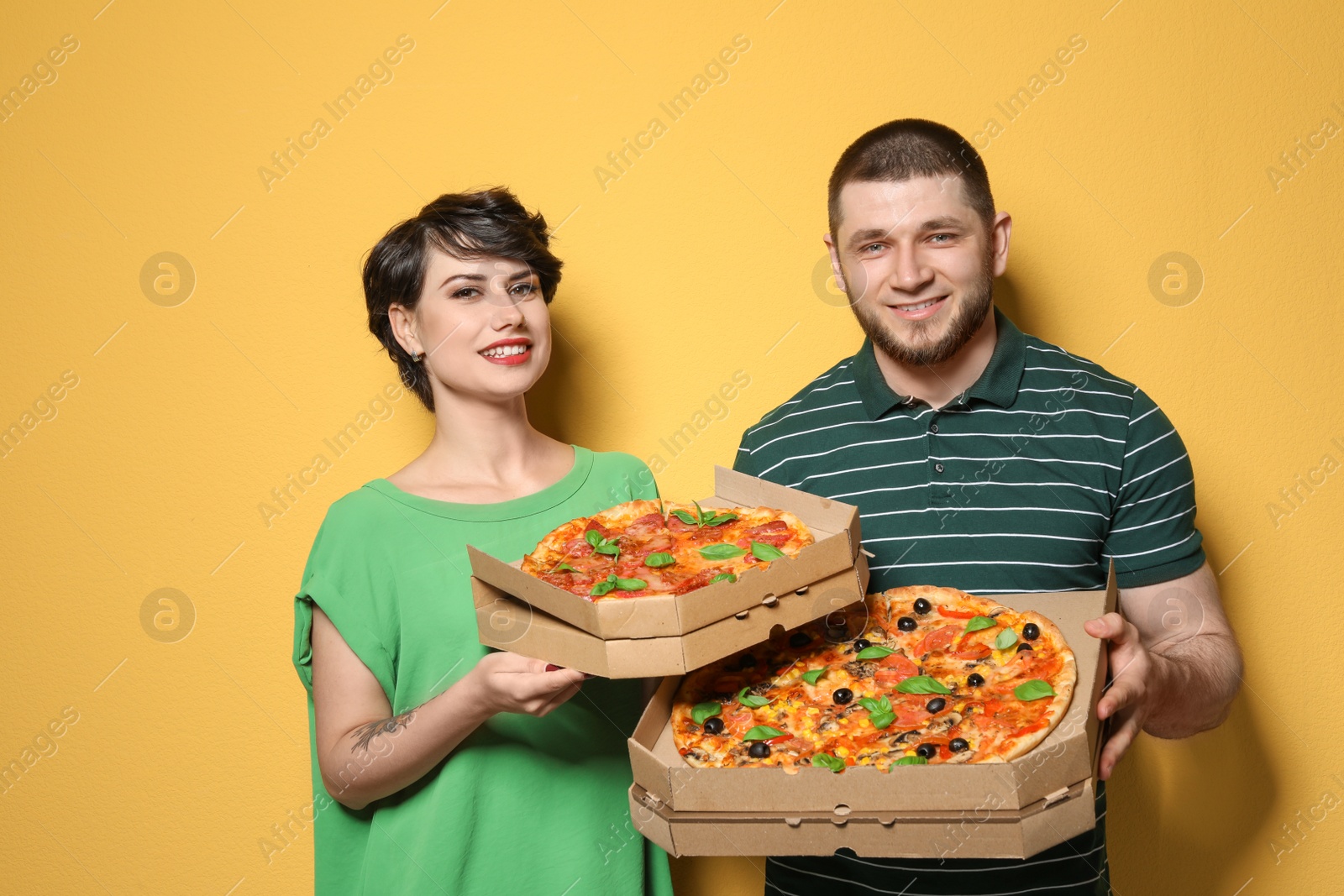 Photo of Attractive young couple with delicious pizza on color background