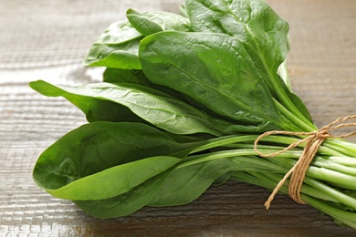 Photo of Bunch of fresh green healthy spinach on wooden table, closeup