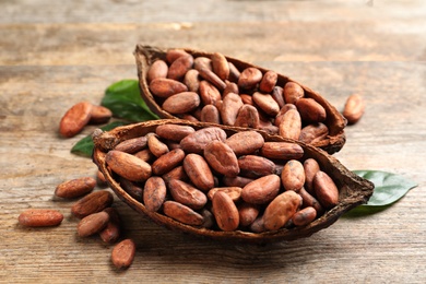 Photo of Cocoa pods and beans on wooden table