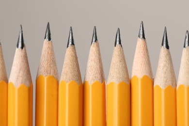 Photo of Many sharp graphite pencils on grey background, macro view