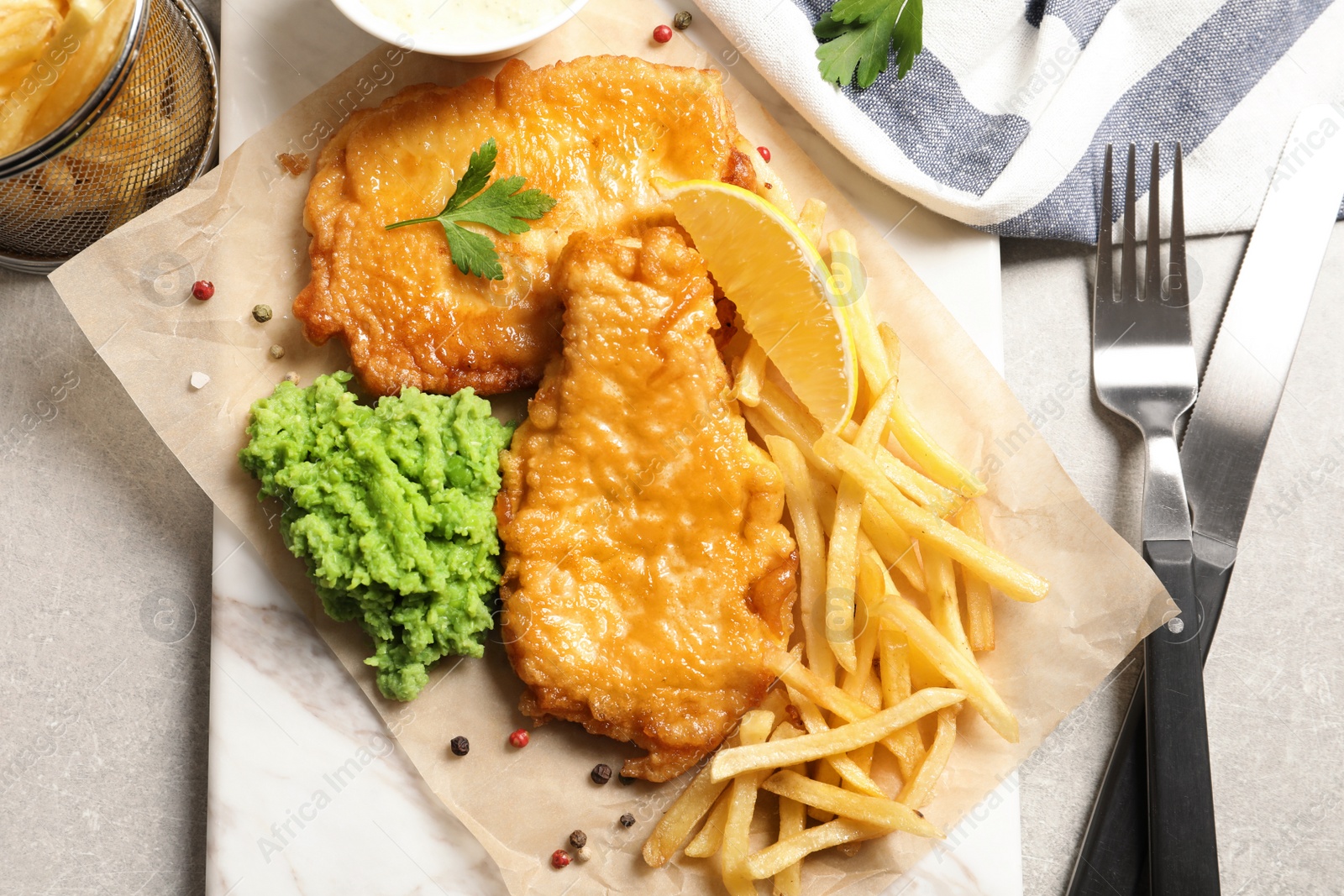 Photo of British traditional fish and potato chips on table, top view