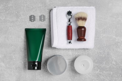 Photo of Set of men's shaving tools on light gray textured table, flat lay