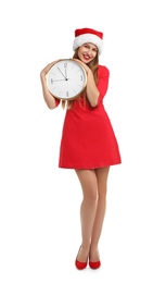 Photo of Young beautiful woman in Santa hat holding big clock on white background. Christmas celebration