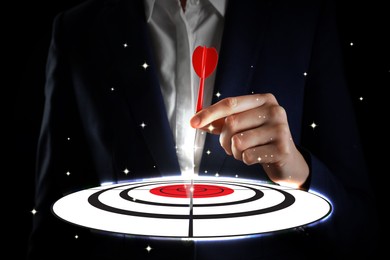 Image of Businesswoman aiming at digital target with dart against dark background, closeup