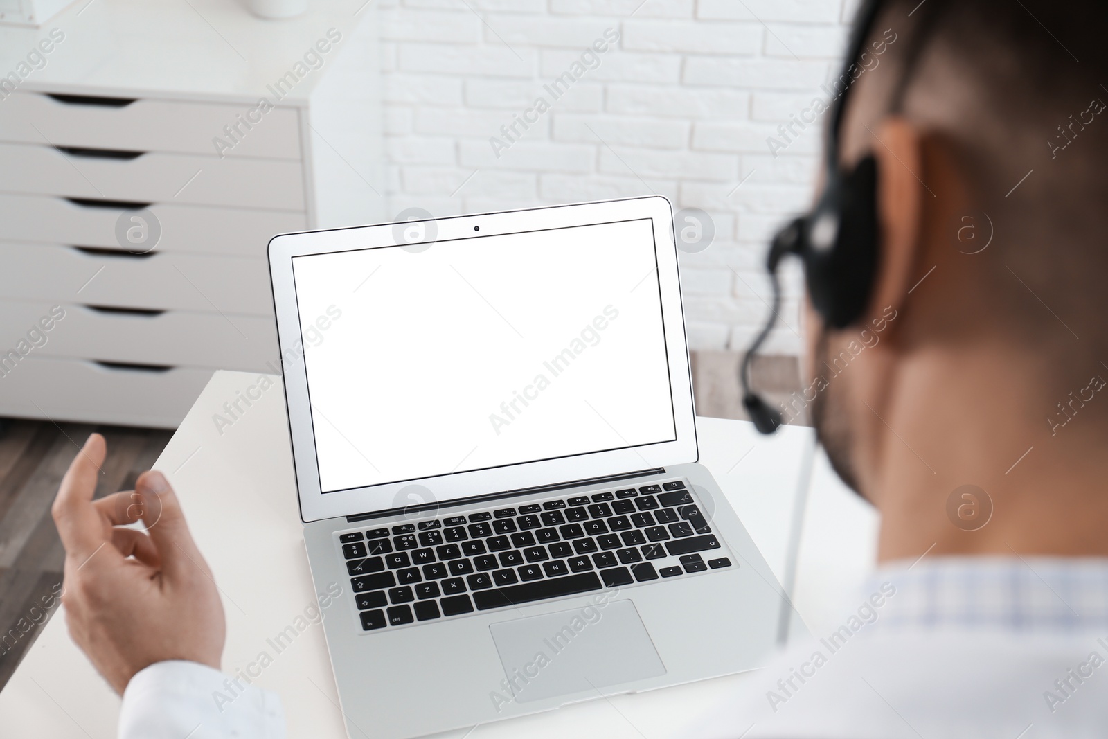 Photo of Doctor with headset consulting patient online at desk in clinic, space for text. Health service hotline