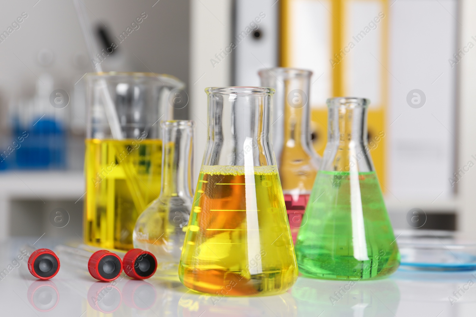 Photo of Laboratory analysis. Different glassware with liquids on white table indoors