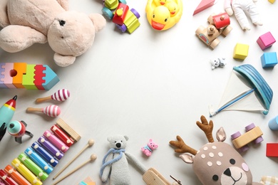 Photo of Frame made of different toys on light background, flat lay. Space for text