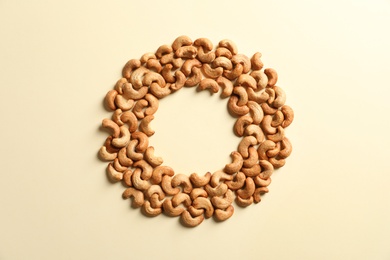 Photo of Frame made with tasty cashew nuts on color background, top view. Space for text