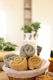 Photo of Basket with towels and dry flowers indoors, space for text. Spa time