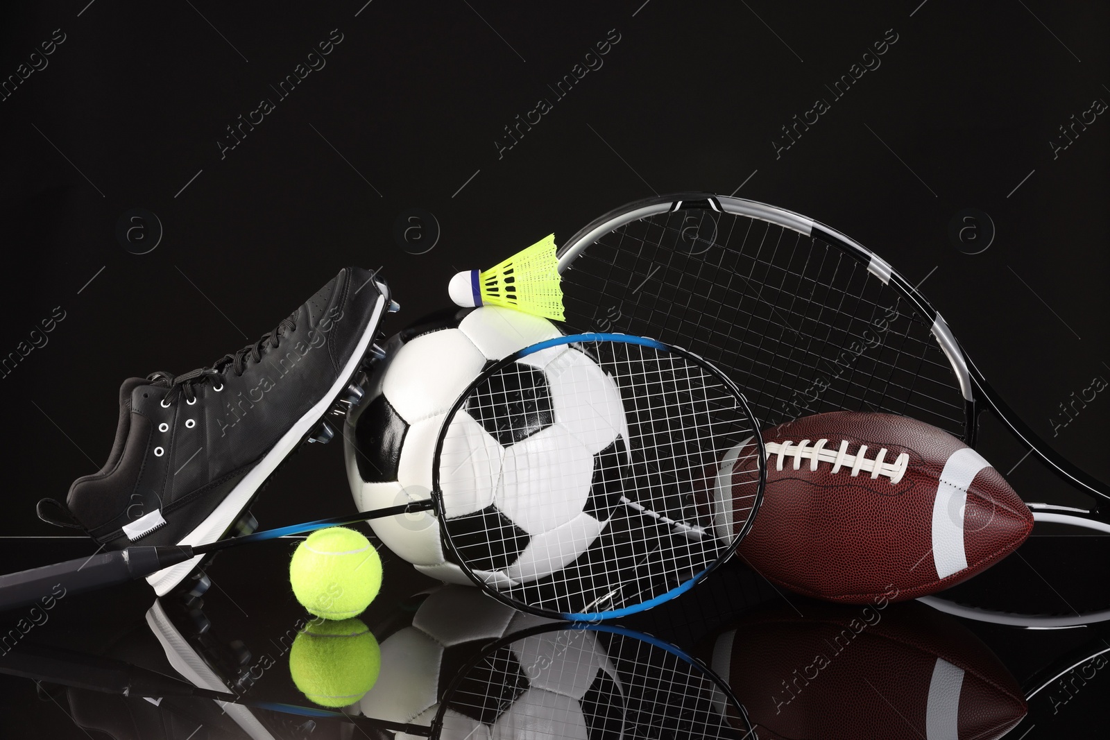 Photo of Many different sports equipment on black mirror surface