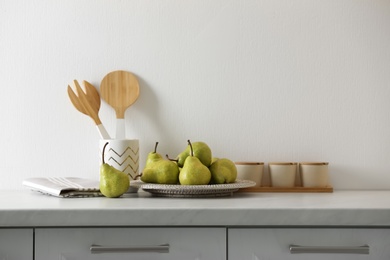 Photo of Plate with fresh ripe pears on white countertop