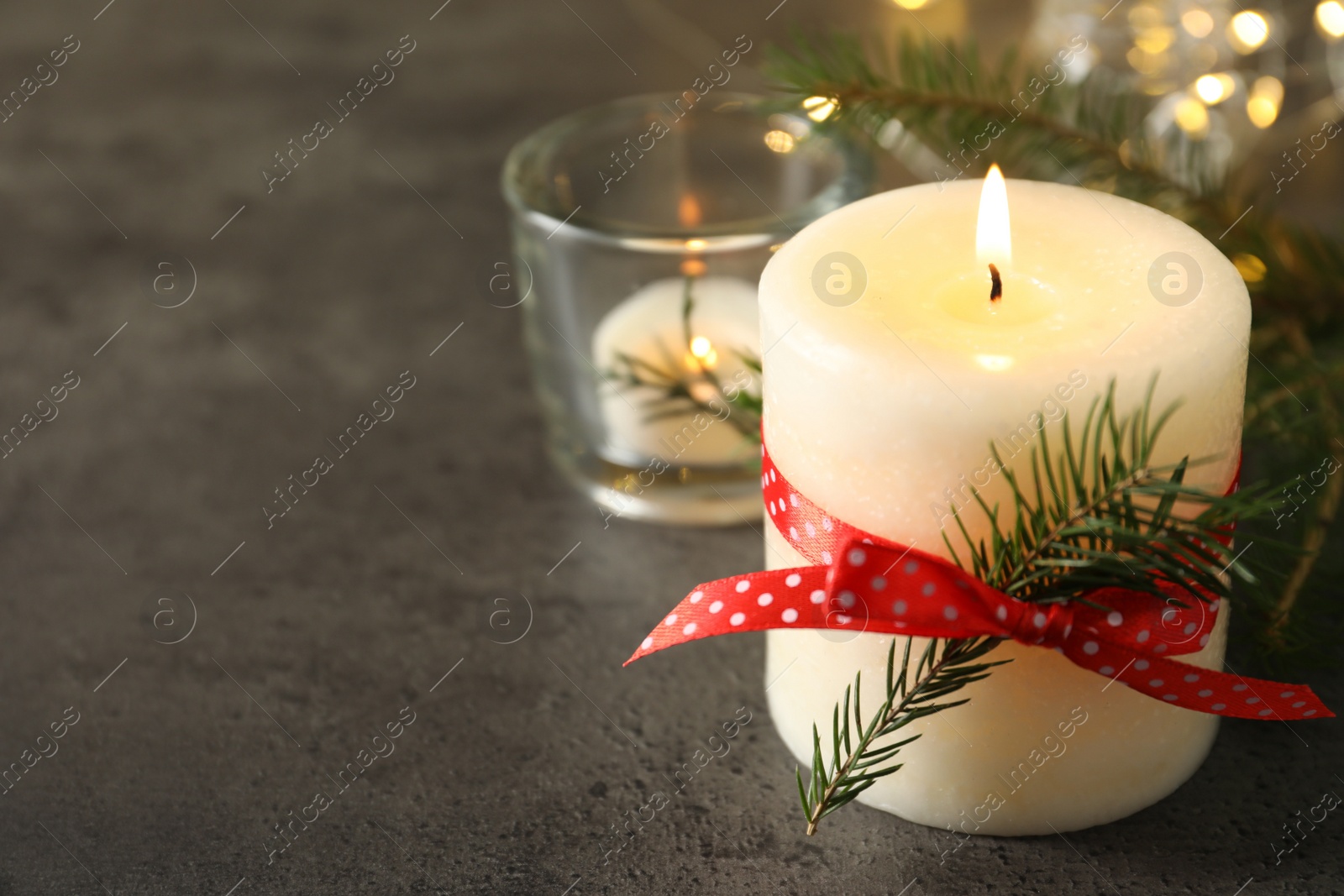 Photo of Burning candle with pinecone scent on black table, space for text