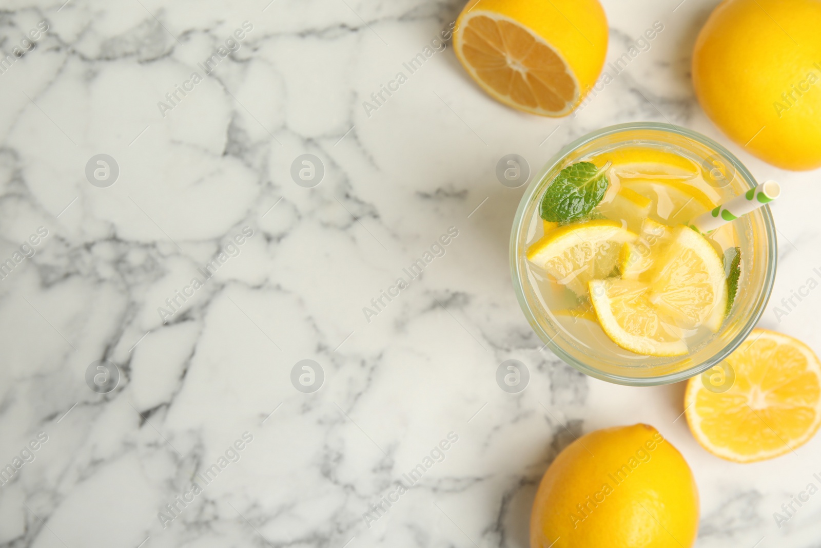 Photo of Cool freshly made lemonade and fruits on white marble table, flat lay. Space for text