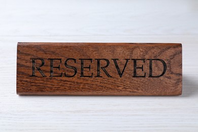 Photo of Elegant wooden sign RESERVED on white table