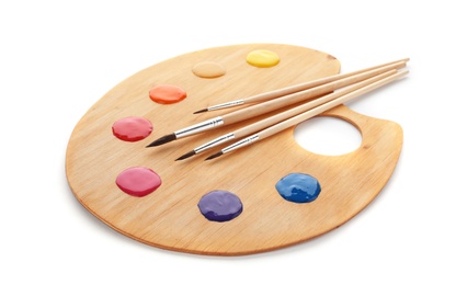 Photo of Palette with paints and brushes on white background