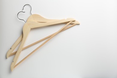 Photo of Wooden hangers on white background, top view. Space for text