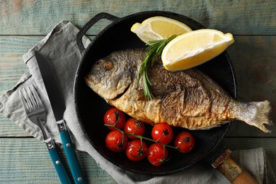 Delicious dorado fish served on wooden table, flat lay