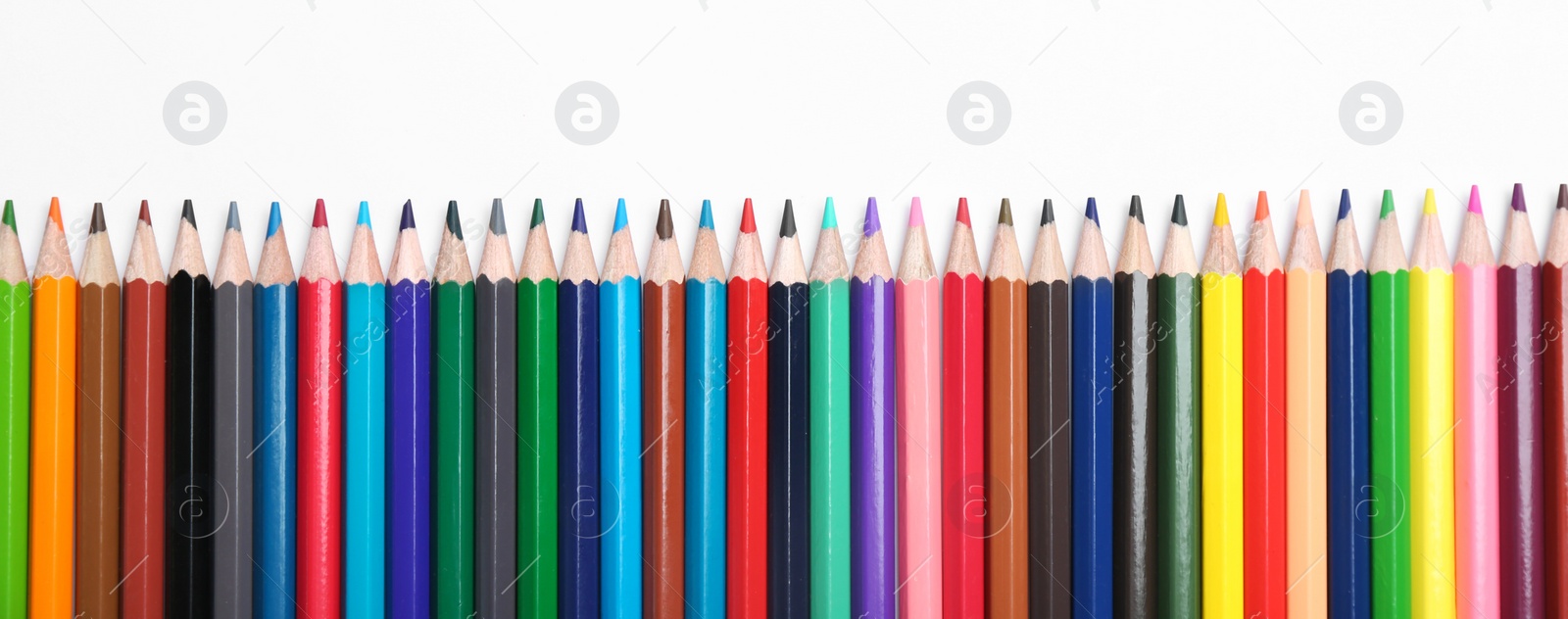 Photo of Color pencils on white background, top view. Space for text