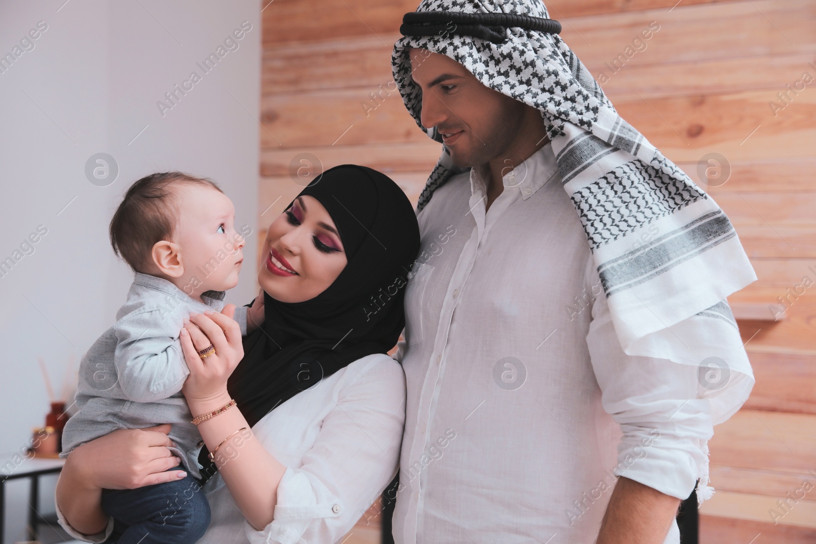 Photo of Happy Muslim family with little son at home