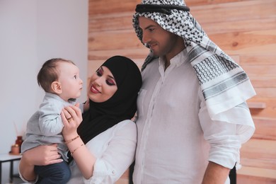 Photo of Happy Muslim family with little son at home