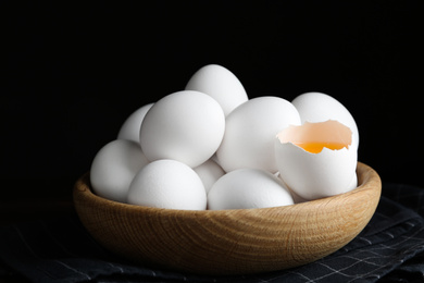 Photo of Many fresh raw chicken eggs in bowl on table