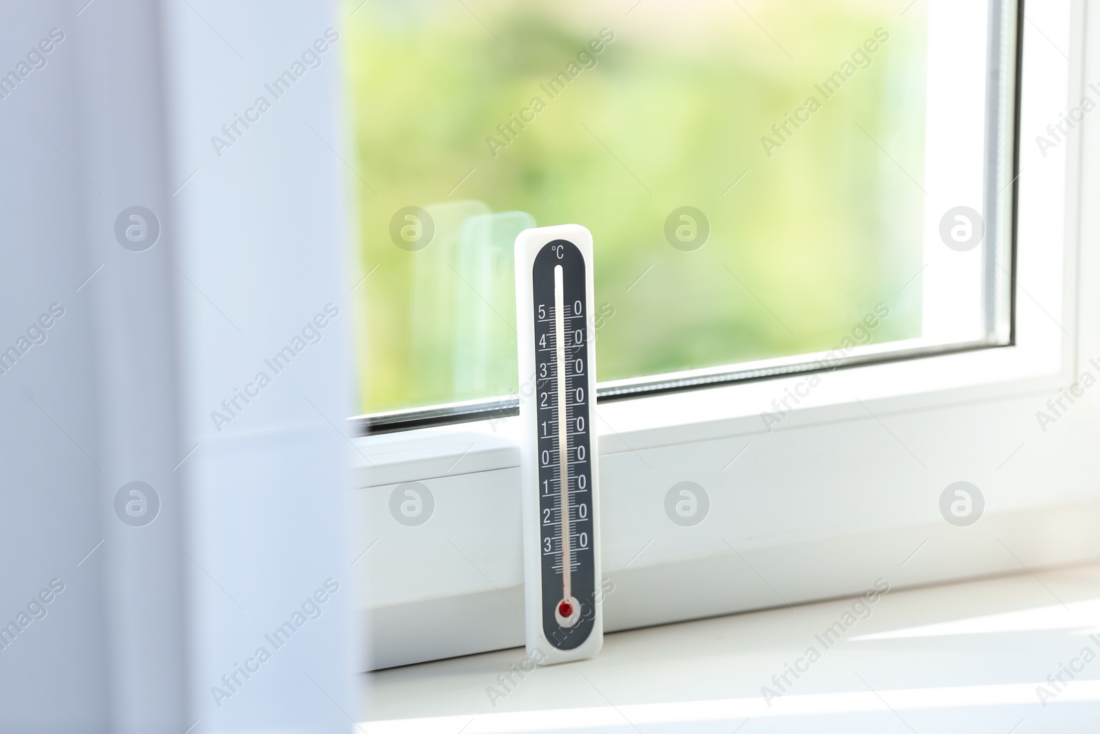 Photo of Grey weather thermometer on window sill indoors