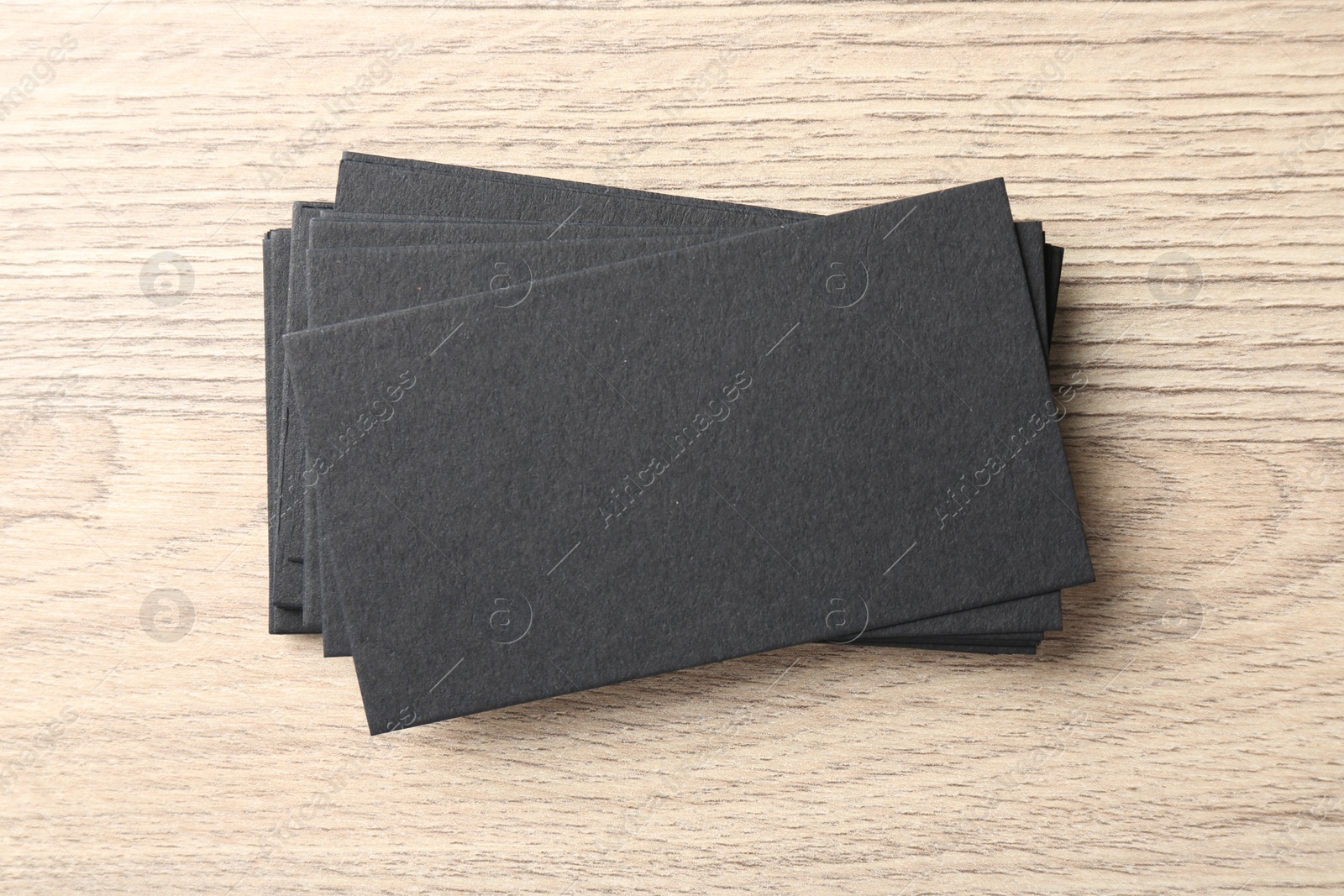Photo of Blank black business cards on wooden table, top view. Mockup for design