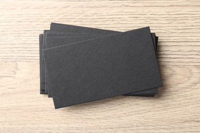 Blank black business cards on wooden table, top view. Mockup for design