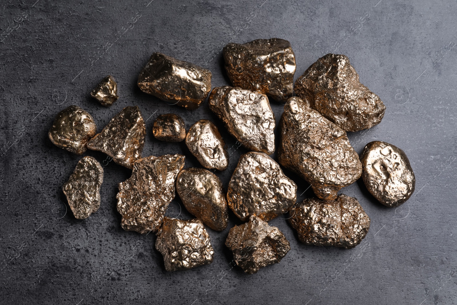 Photo of Pile of gold nuggets on grey table, flat lay