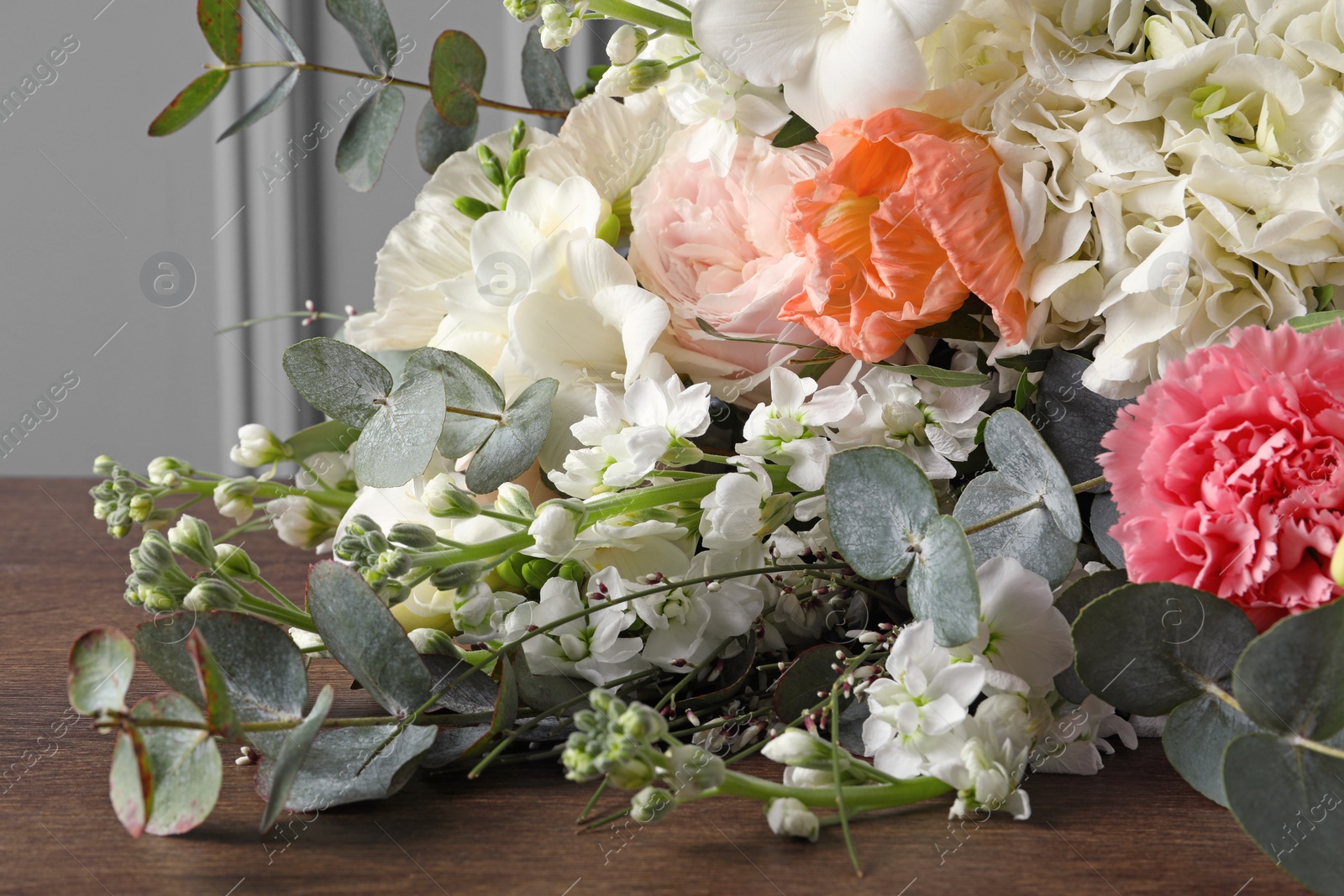 Photo of Bouquet of beautiful flowers on wooden table, closeup