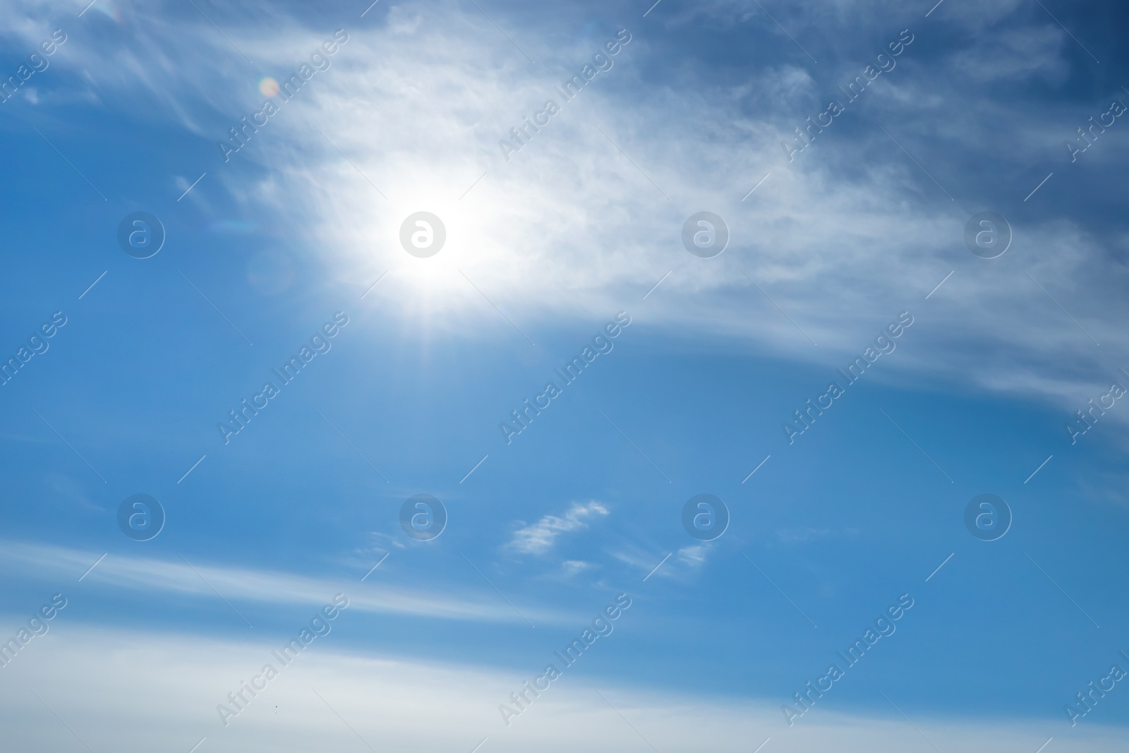 Photo of Bright sun and fluffy white clouds in blue sky