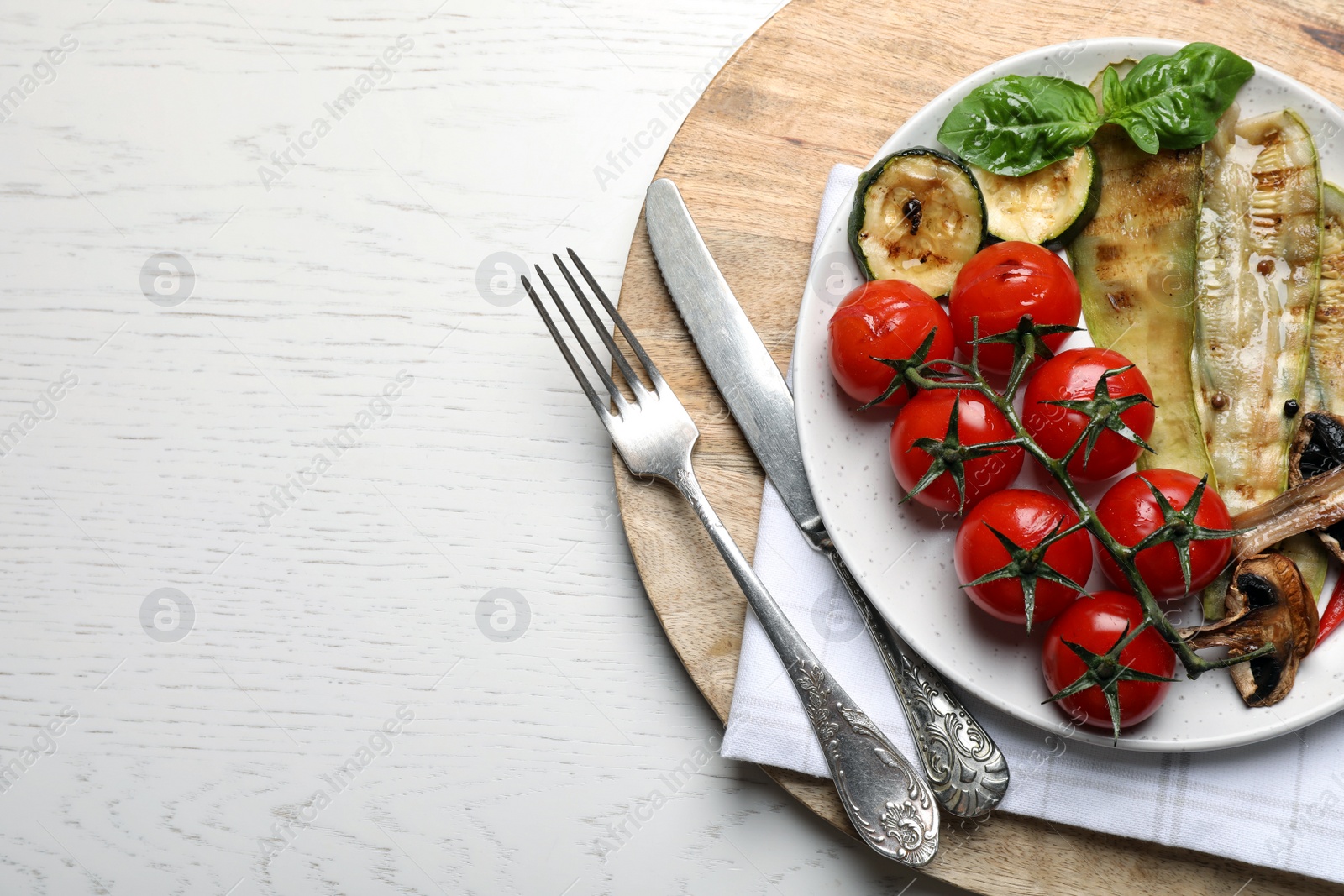 Photo of Delicious grilled vegetables served on white wooden table, top view. Space for text