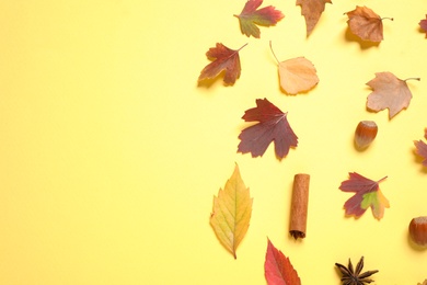 Flat lay composition with autumn leaves on yellow background. Space for text