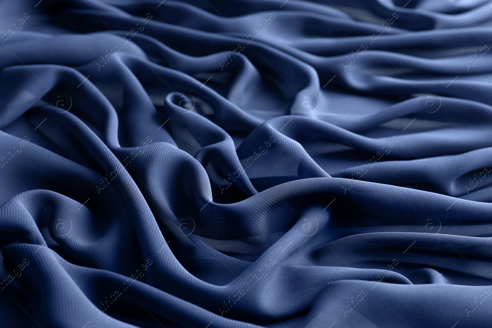 Photo of Beautiful dark blue tulle fabric as background, closeup