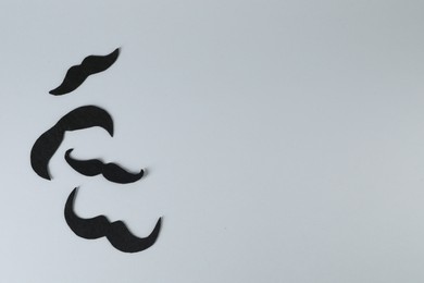 Fake paper mustaches on grey background, flat lay. Space for text