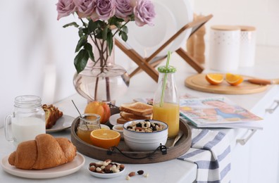 Photo of Tray with tasty breakfast on white table in morning.  Space for text