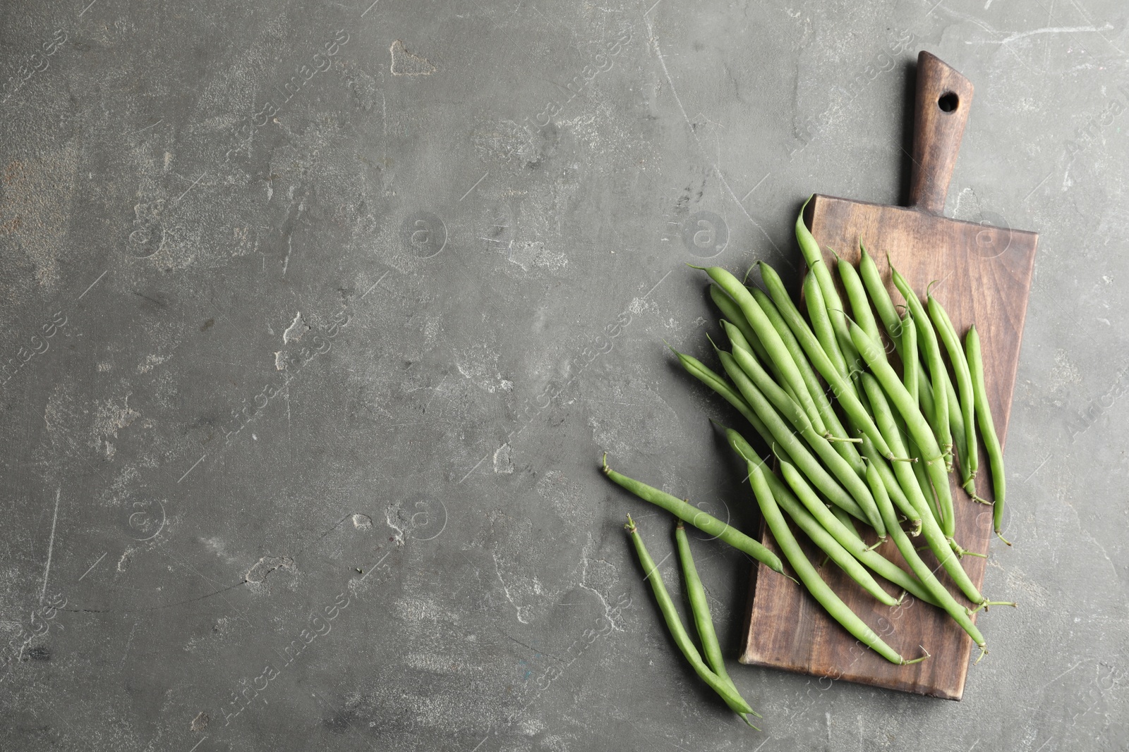 Photo of Fresh green beans on grey table, flat lay. Space for text